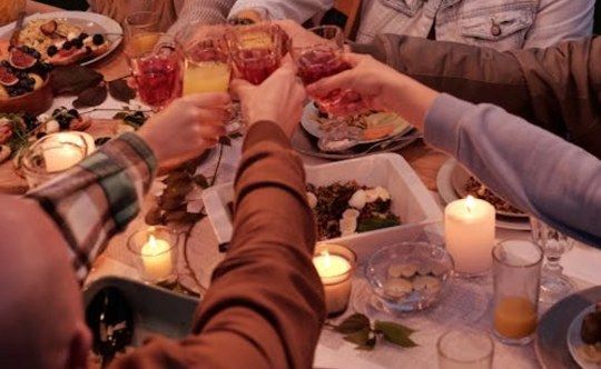 Friends raising glasses over a candlelit dinner table