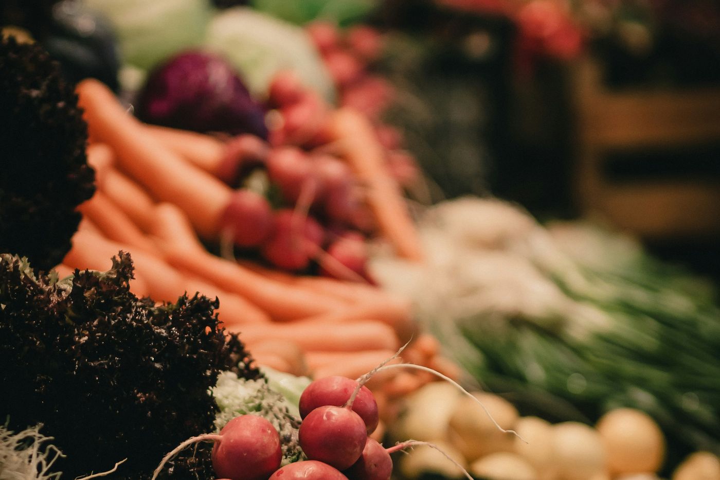 Carrots, radishes and other fresh produce at a market stall