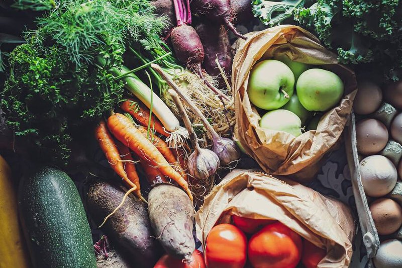 Fresh vegetables, apples and eggs spread on a table